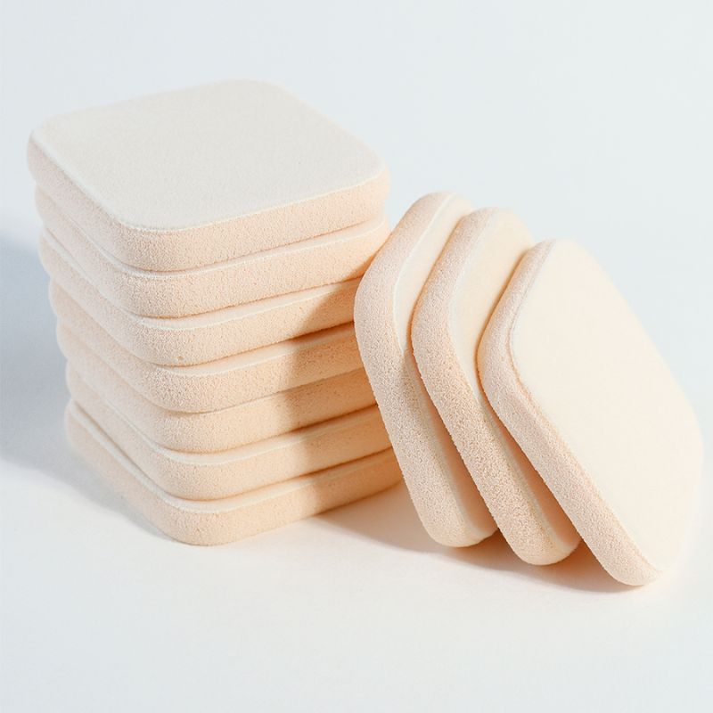 Esponja compacta de doble capa con parte superior suave y base firme en beige. Garantiza una recogida y liberación de polvo consistentes — escalable desde 5,000 unidades con materiales compatibles con la FDA